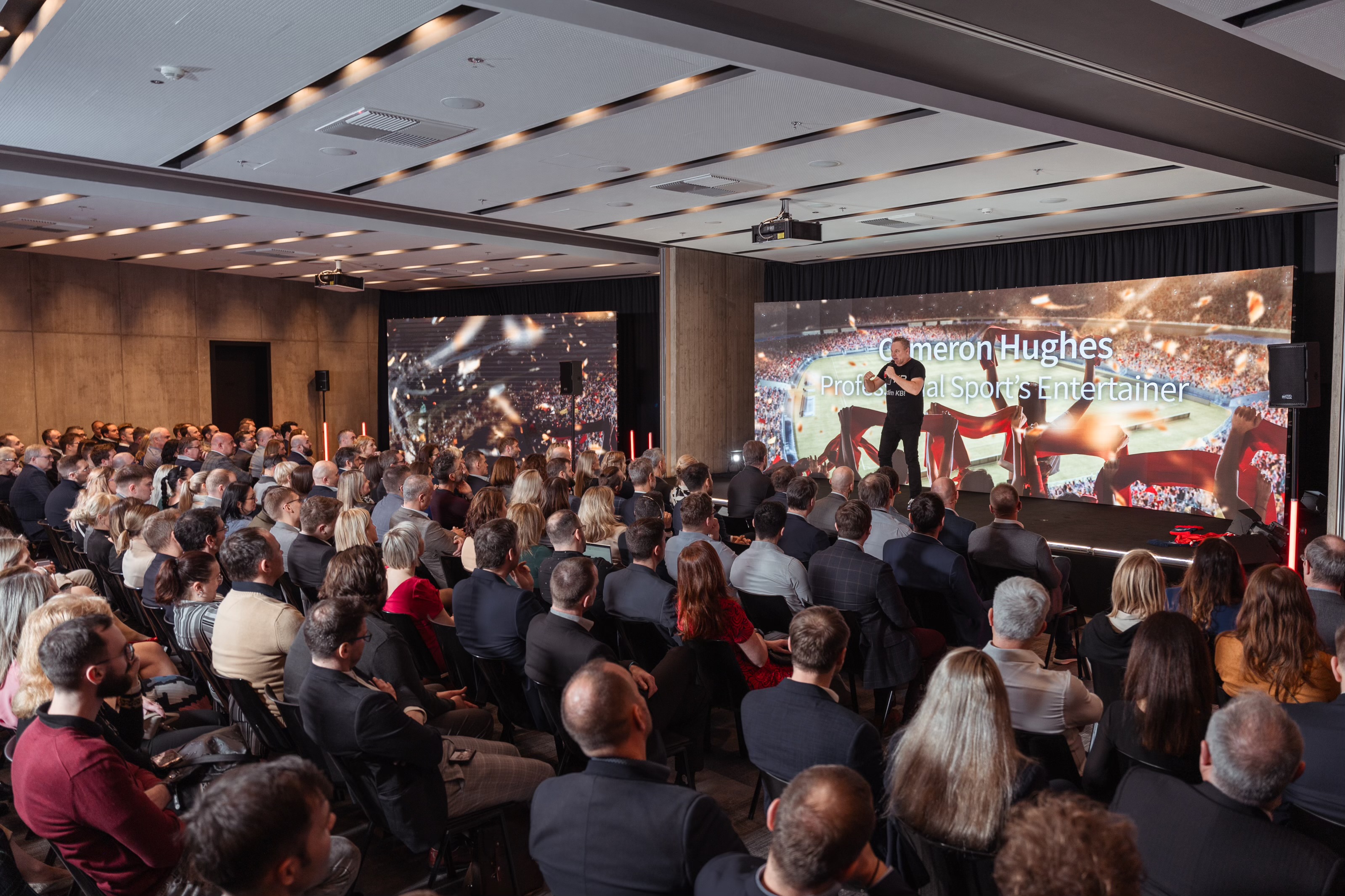 Cameron Hughes delivering a high-energy keynote on stage